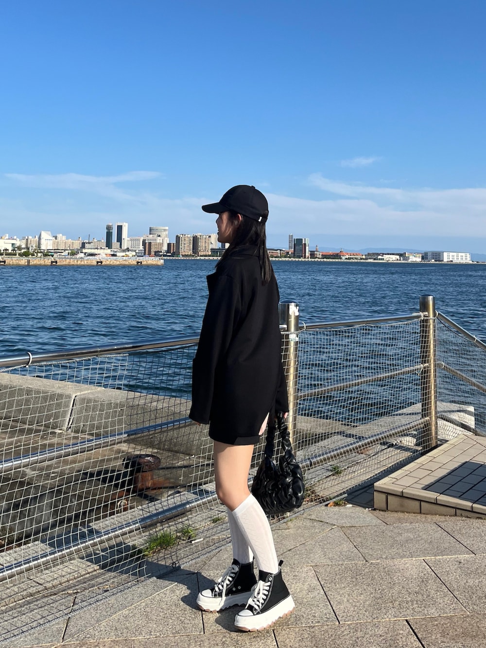 ブラック系のテーラードジャケット、ピンク系のその他トップス、ブラック系のシューズを着用したレディースの春コーディネートの4枚目の写真