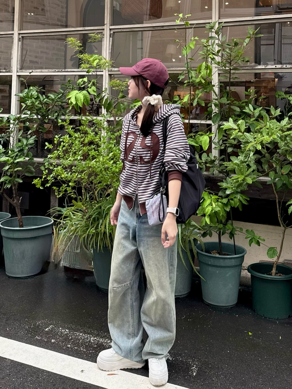 ブルー系のデニムパンツ、ホワイト系のスニーカー、ブラック系のトートバッグを着用したレディースの秋コーディネートの3枚目の写真