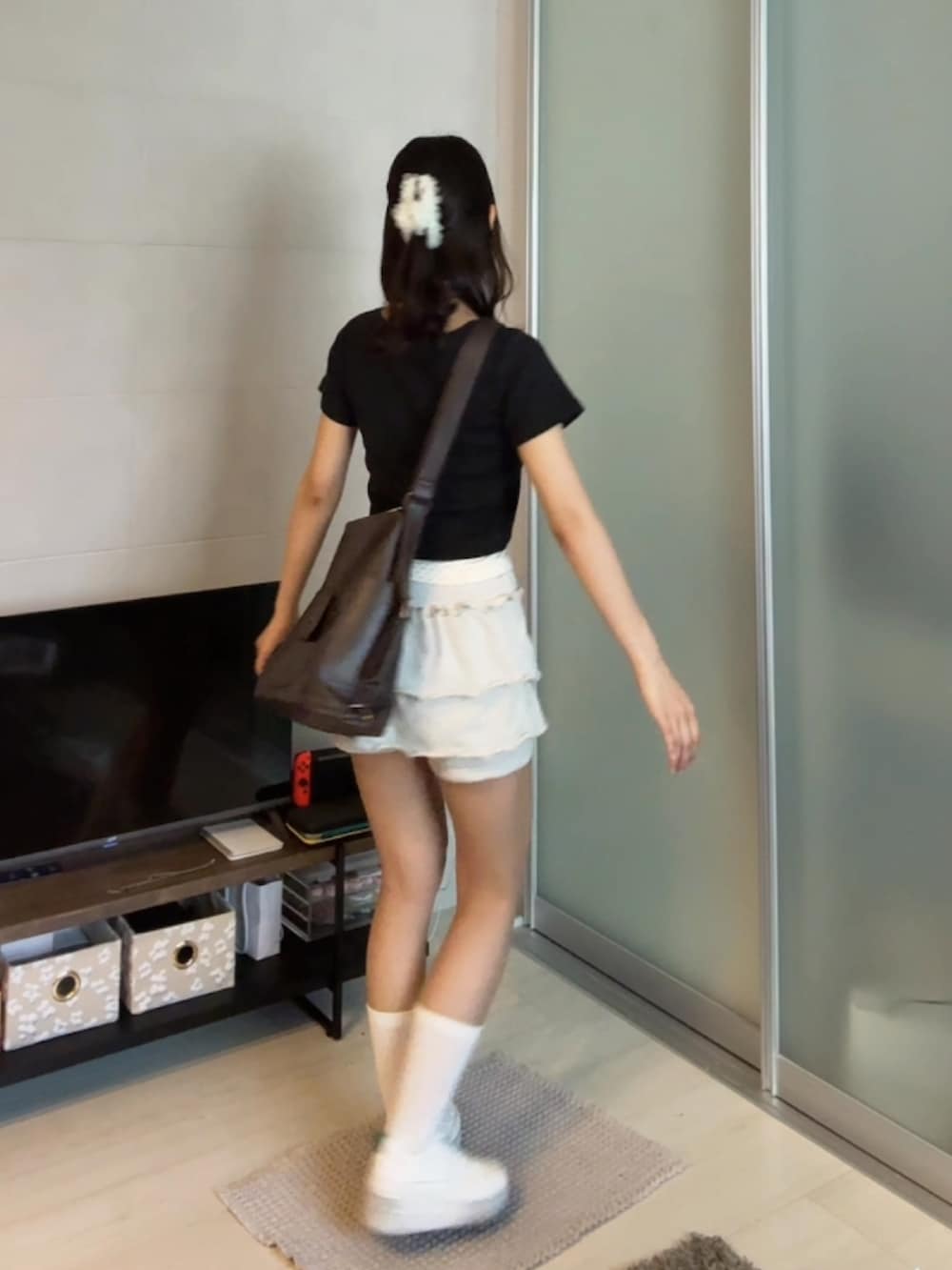 ホワイト系のスニーカー、ホワイト系のスウェットパンツ、ブラック系のTシャツ/カットソーを着用したレディースの夏コーディネートの3枚目の写真