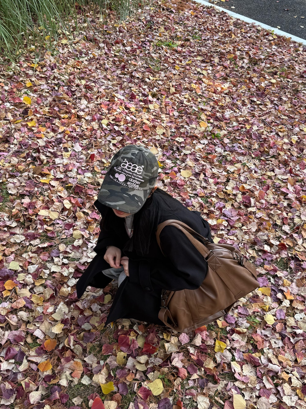 ブラウン系のボストンバッグ、ブラック系のその他アウター、ブラック系のスニーカーを着用したレディースの冬コーディネートの4枚目の写真