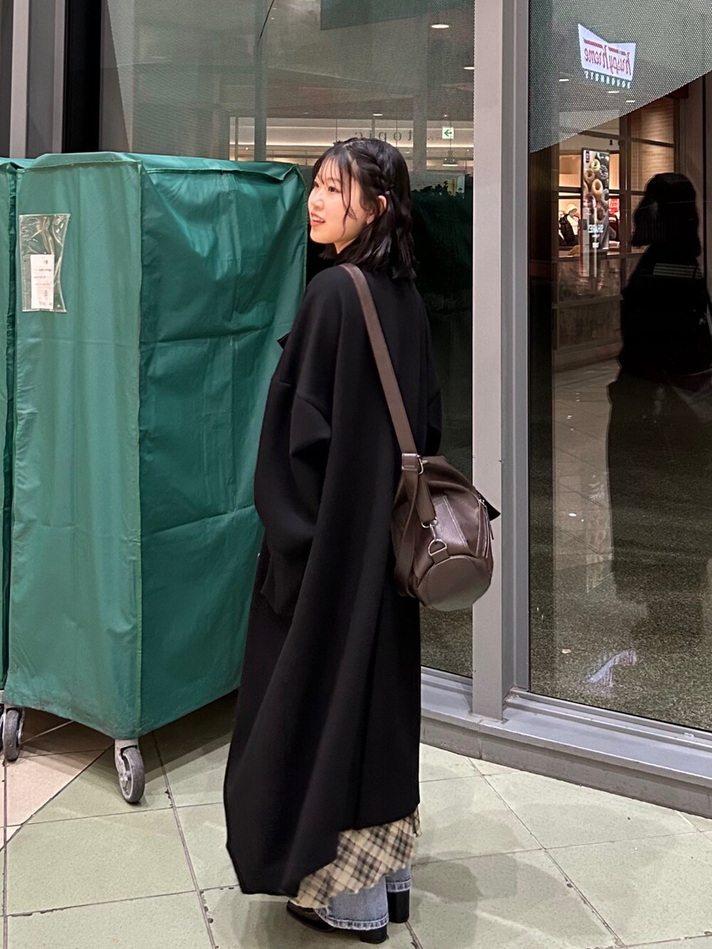 ブラック系のブーツ、ブラック系のジャケット/アウター、ベージュ系のワンピースを着用したレディースの冬コーディネートの2枚目の写真