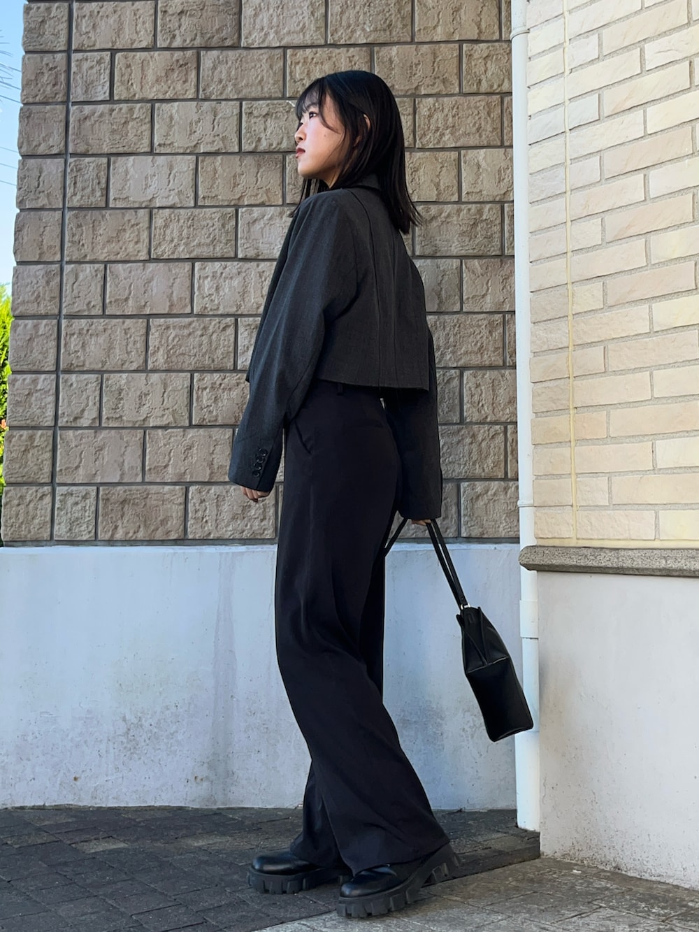 ブラック系のショルダーバッグ、ブラック系のブーツ、ブラック系のTシャツ/カットソーを着用したレディースの秋コーディネートの2枚目の写真