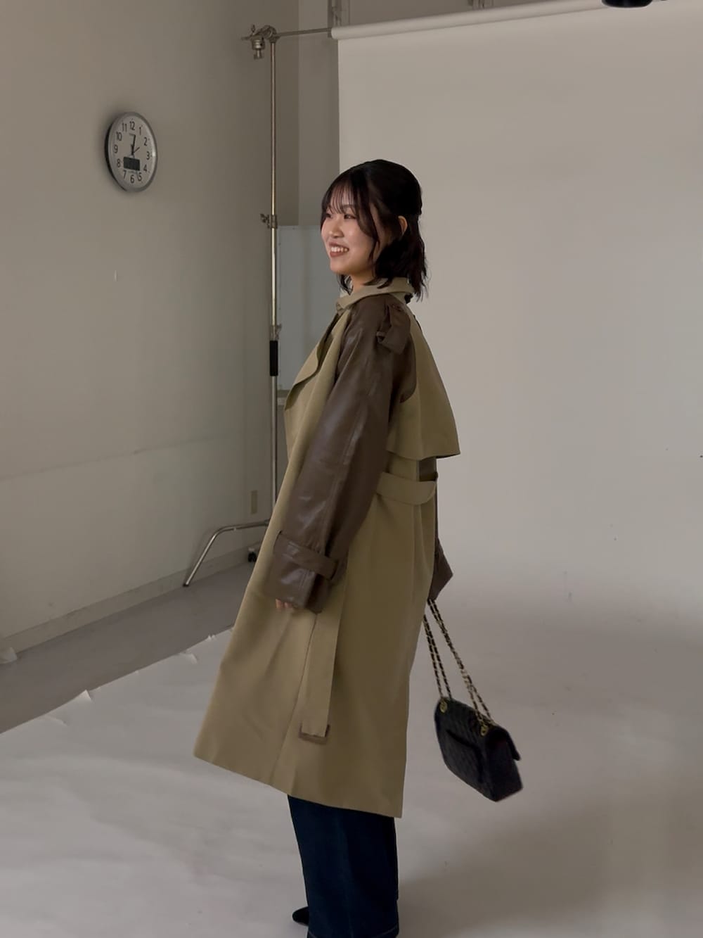 ブラック系のショルダーバッグ、ベージュ系のトレンチコート、レッド系のニット/セーターを着用したレディースの冬コーディネートの3枚目の写真