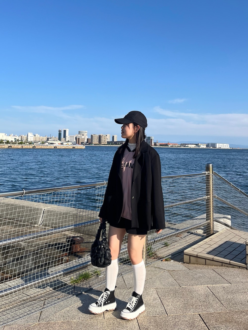 ブラック系のテーラードジャケット、ピンク系のその他トップス、ブラック系のシューズを着用したレディースの春コーディネートの3枚目の写真