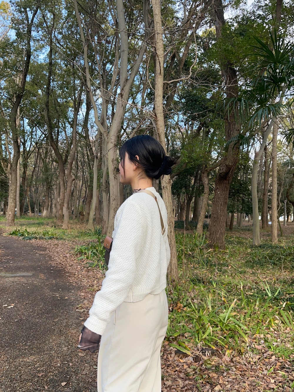 ホワイト系のスラックス、ホワイト系のスニーカー、ブラウン系のボディバッグ/ウエストポーチを着用したレディースの冬コーディネートの3枚目の写真