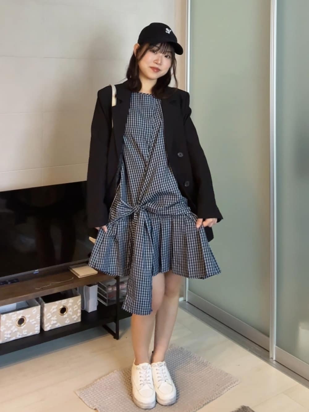 ホワイト系のスニーカー、ブルー系のTシャツ/カットソー、ブラック系のテーラードジャケットを着用したレディースの夏コーディネートの2枚目の写真