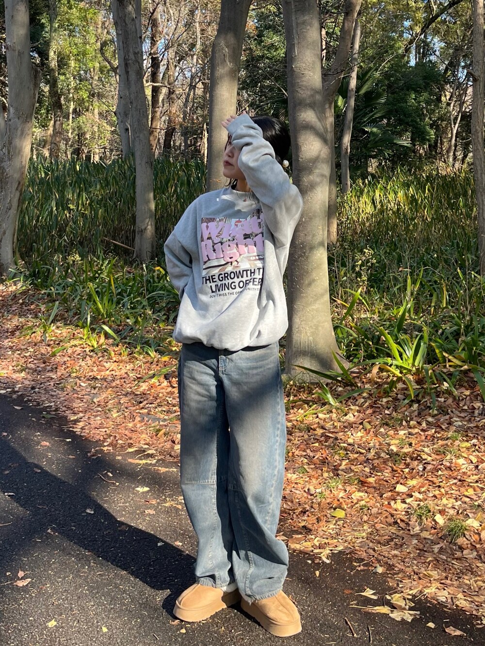 ブルー系のデニムパンツ、ベージュ系のブーツ、グレー系のスウェットを着用したレディースの冬コーディネートの4枚目の写真