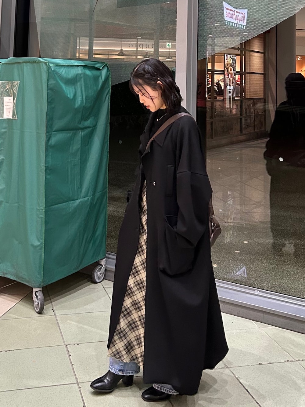 ブラック系のブーツ、ブラック系のジャケット/アウター、ベージュ系のワンピースを着用したレディースの冬コーディネートの3枚目の写真