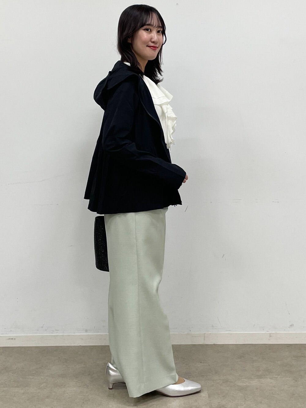 シルバー系のパンプス、ホワイト系のシャツ/ブラウス、ブラック系のブルゾンを着用したレディースの春コーディネートの5枚目の写真