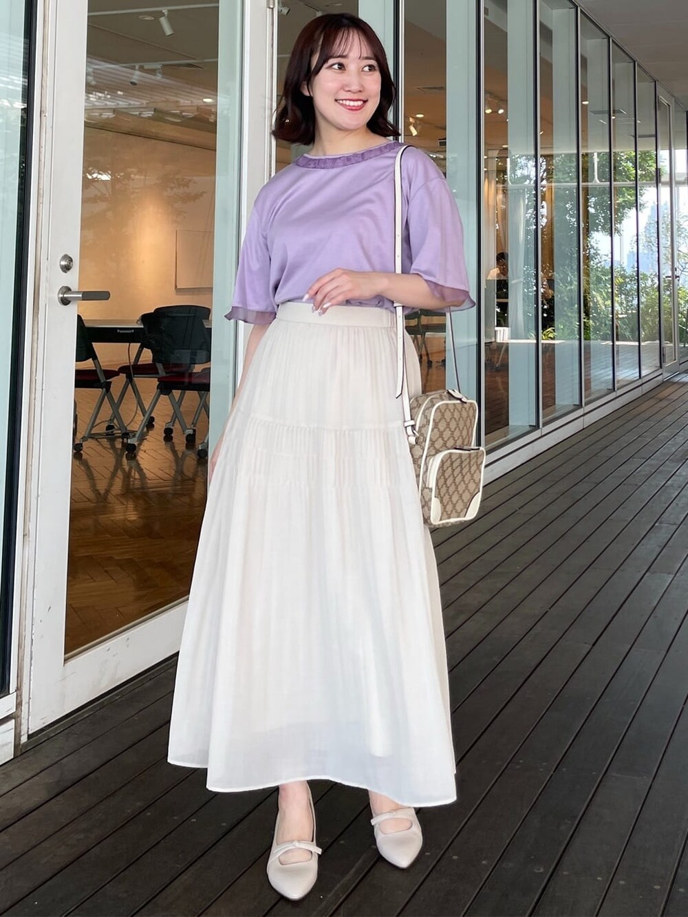 パープル系のTシャツ/カットソー、ベージュ系のスカート、イエロー系のショルダーバッグを着用したレディースの夏コーディネートの3枚目の写真