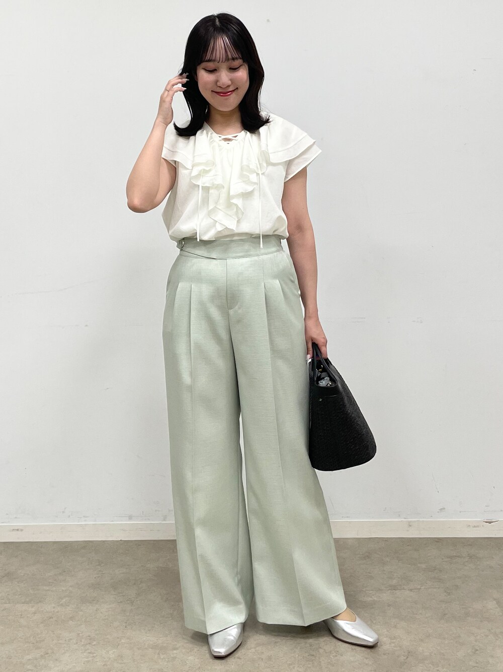 シルバー系のパンプス、ホワイト系のシャツ/ブラウス、ブラック系のブルゾンを着用したレディースの春コーディネートの2枚目の写真
