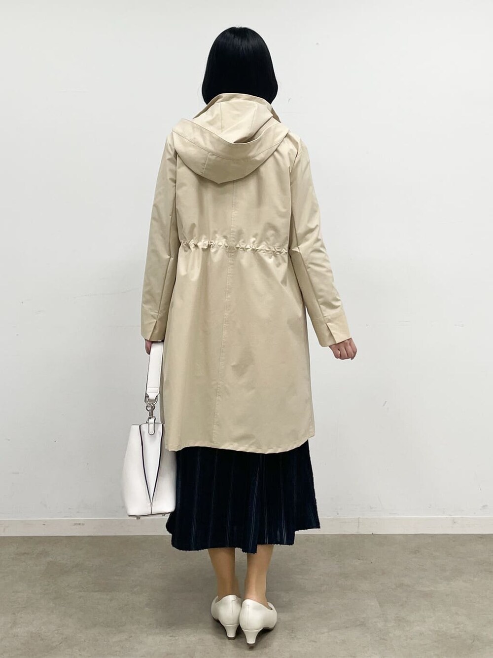 ブルー系のニット/セーター、ブルー系のスカート、ベージュ系のその他アウターを着用したレディースの冬コーディネートの6枚目の写真