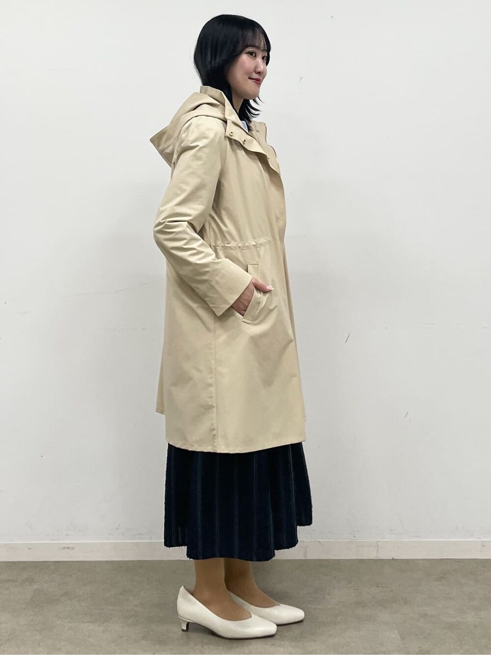 ブルー系のニット/セーター、ブルー系のスカート、ベージュ系のその他アウターを着用したレディースの冬コーディネートの5枚目の写真