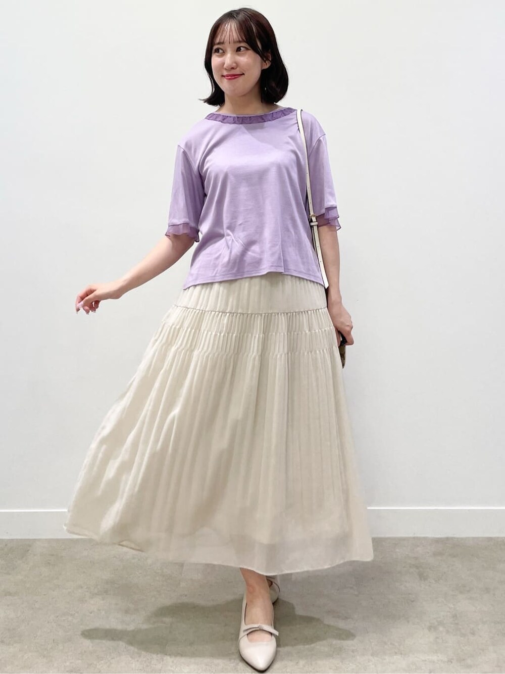 パープル系のTシャツ/カットソー、ベージュ系のスカート、イエロー系のショルダーバッグを着用したレディースの夏コーディネートの6枚目の写真
