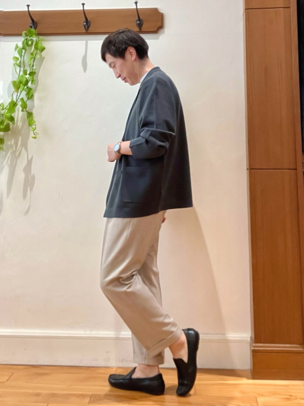 グリーン系のテーラードジャケット、ホワイト系のTシャツ/カットソー、ベージュ系のスラックスを着用したメンズの冬コーディネートの3枚目の写真