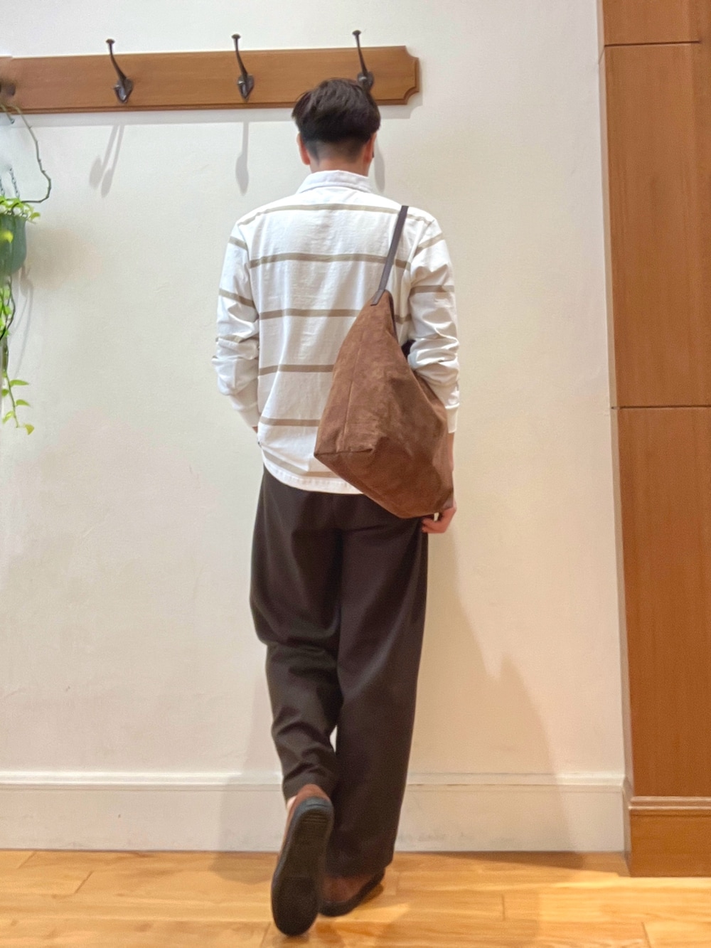 イエロー系のショルダーバッグ、ブラウン系のスニーカー、ホワイト系のTシャツ/カットソーを着用したメンズの秋コーディネートの6枚目の写真