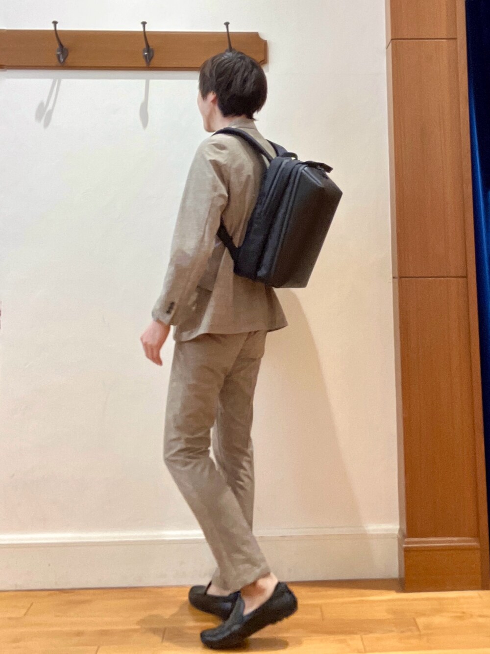 ベージュ系のその他パンツ、ブラック系のバックパック/リュック、ブルー系のTシャツ/カットソーを着用したメンズの春コーディネートの4枚目の写真