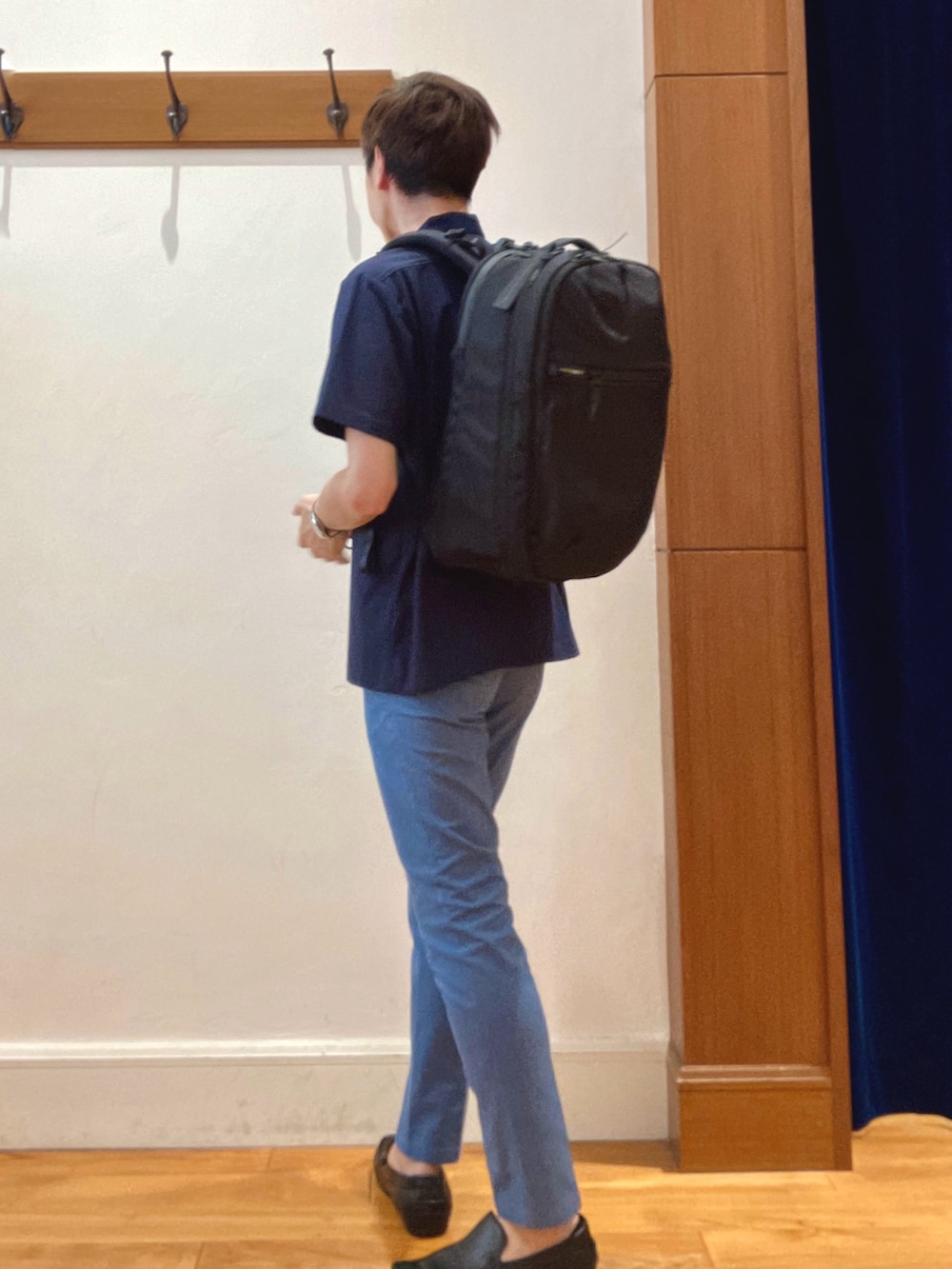 ブルー系のチノパンツ、ブラック系のバックパック/リュック、ブルー系のポロシャツを着用したメンズの夏コーディネートの3枚目の写真