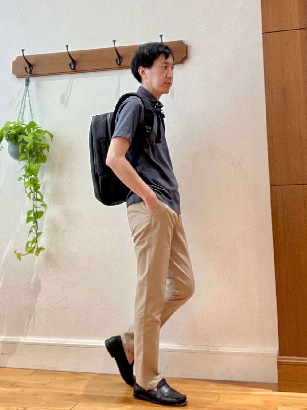 グレー系のポロシャツ、ブラック系のバックパック/リュック、ベージュ系のその他パンツを着用したメンズの春コーディネートの8枚目の写真