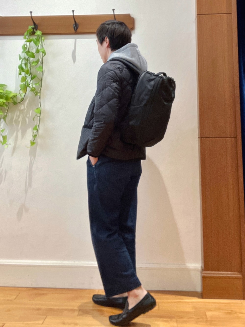 ブラック系のダウンジャケット/コート、グレー系のパーカー、ブラック系のバックパック/リュックを着用したメンズの秋コーディネートの4枚目の写真