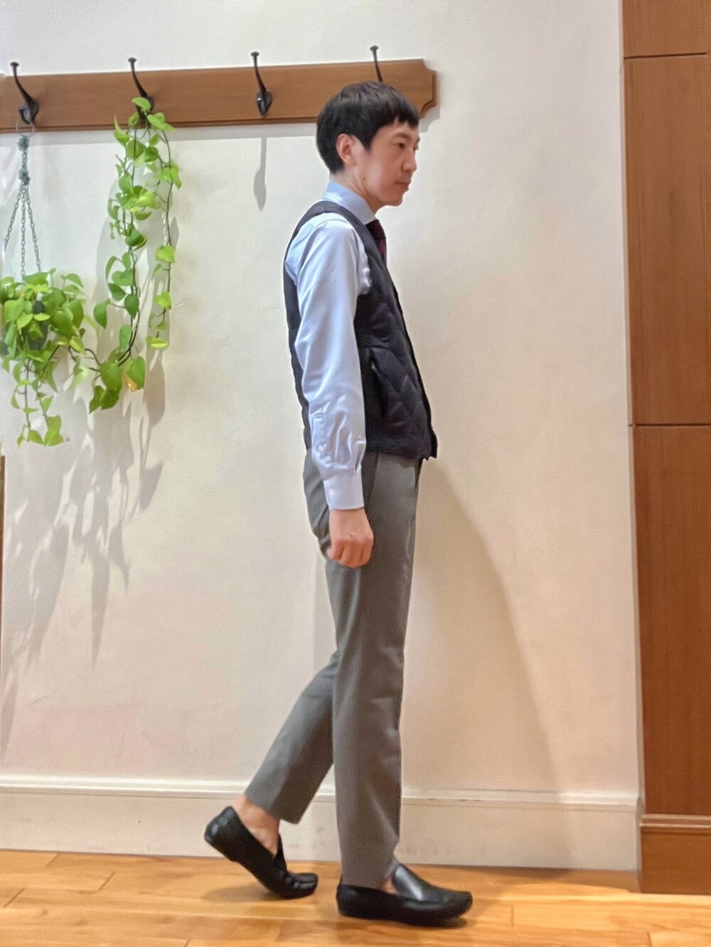 グレー系のその他パンツ、ブルー系のビジネスシャツ、ブルー系のダウンベストを着用したメンズの秋コーディネートの6枚目の写真