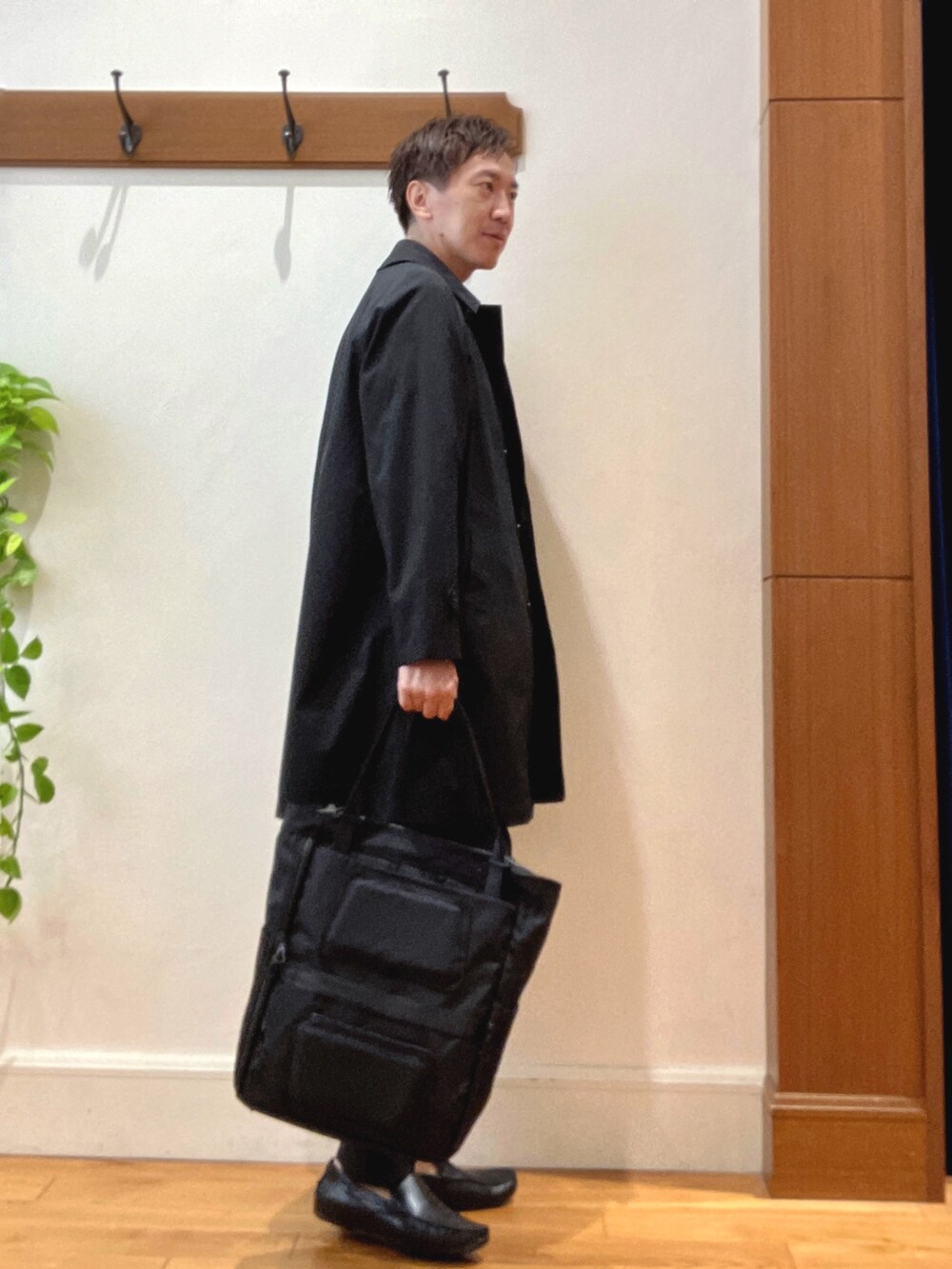 ブラック系のステンカラーコート、グレー系のTシャツ/カットソー、ブラック系のその他パンツを着用したメンズの夏コーディネートの5枚目の写真