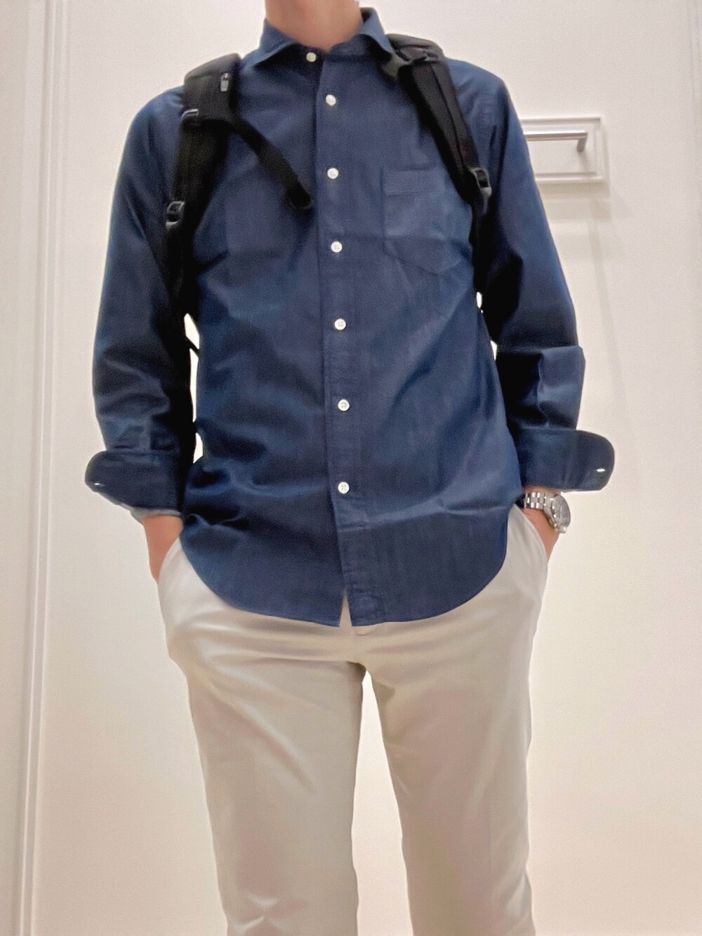 ブラック系のバックパック/リュック、グレー系のチノパンツ、ブルー系のシャツ/ブラウスを着用したメンズの冬コーディネートの8枚目の写真