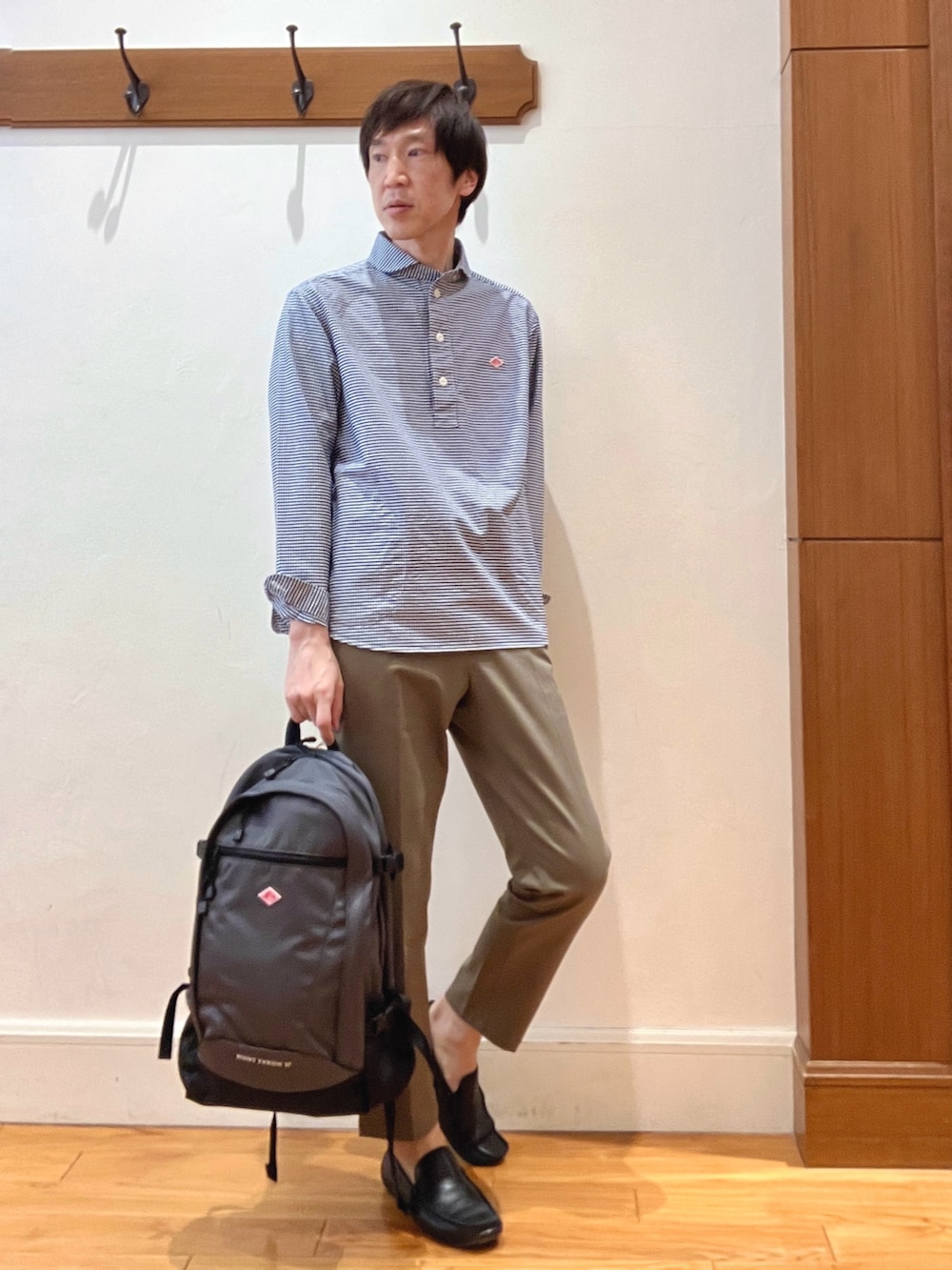 ブルー系のシャツ/ブラウス、グレー系のバックパック/リュック、グリーン系のチノパンツを着用したメンズの春コーディネートの7枚目の写真