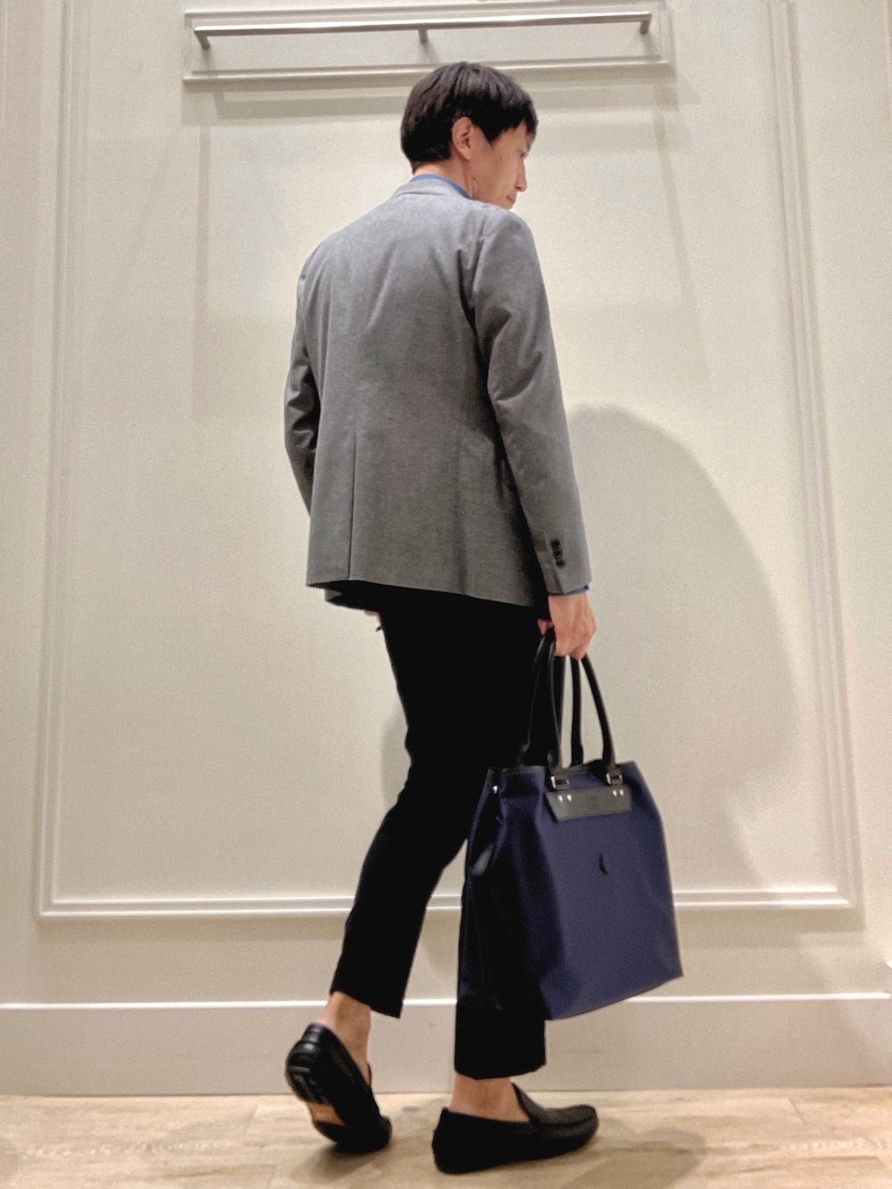 グレー系のテーラードジャケット、ブルー系のシャツ/ブラウス、ブラック系のトートバッグを着用したメンズの秋コーディネートの3枚目の写真