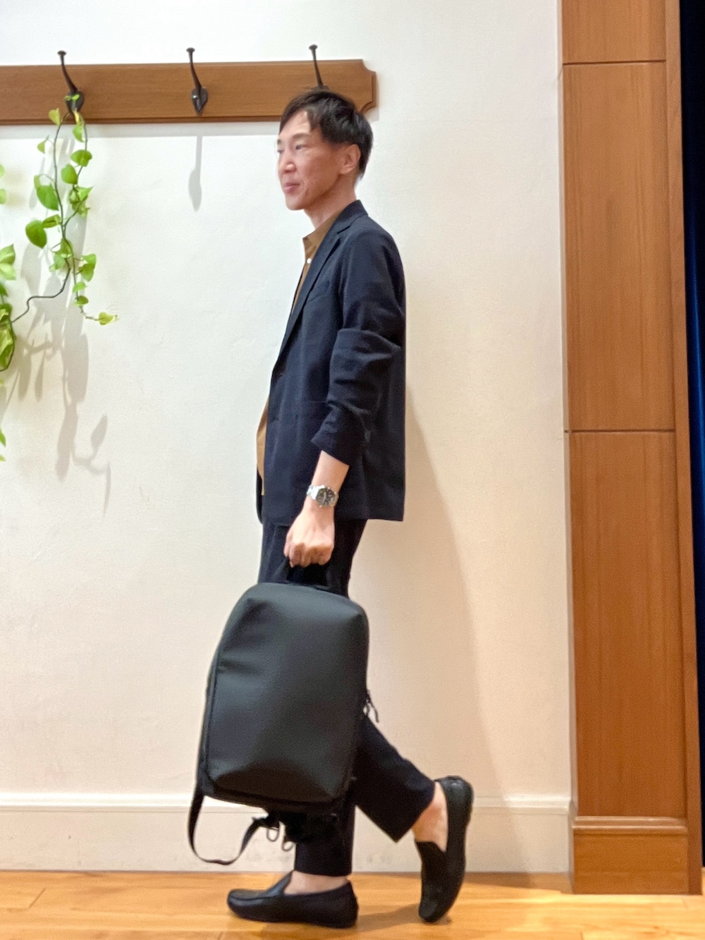 ブラック系のテーラードジャケット、ブラック系のその他パンツ、ブラック系のバックパック/リュックを着用したメンズの夏コーディネートの3枚目の写真