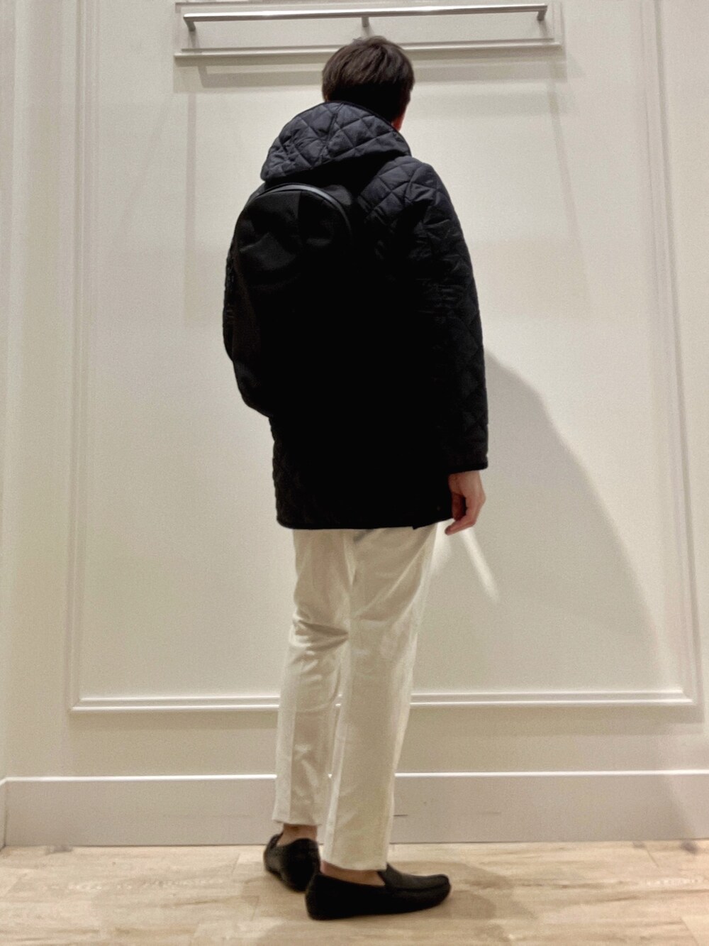 ブルー系のステンカラーコート、ブルー系のニット/セーター、ホワイト系のチノパンツを着用したメンズの冬コーディネートの7枚目の写真