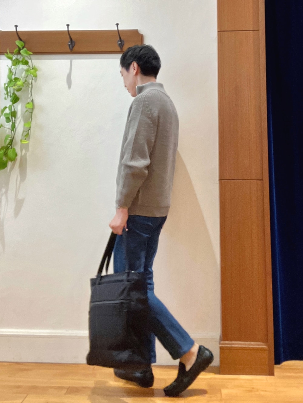 グレー系のニット/セーター、ホワイト系のシャツ/ブラウス、ブルー系のデニムパンツを着用したメンズの秋コーディネートの3枚目の写真