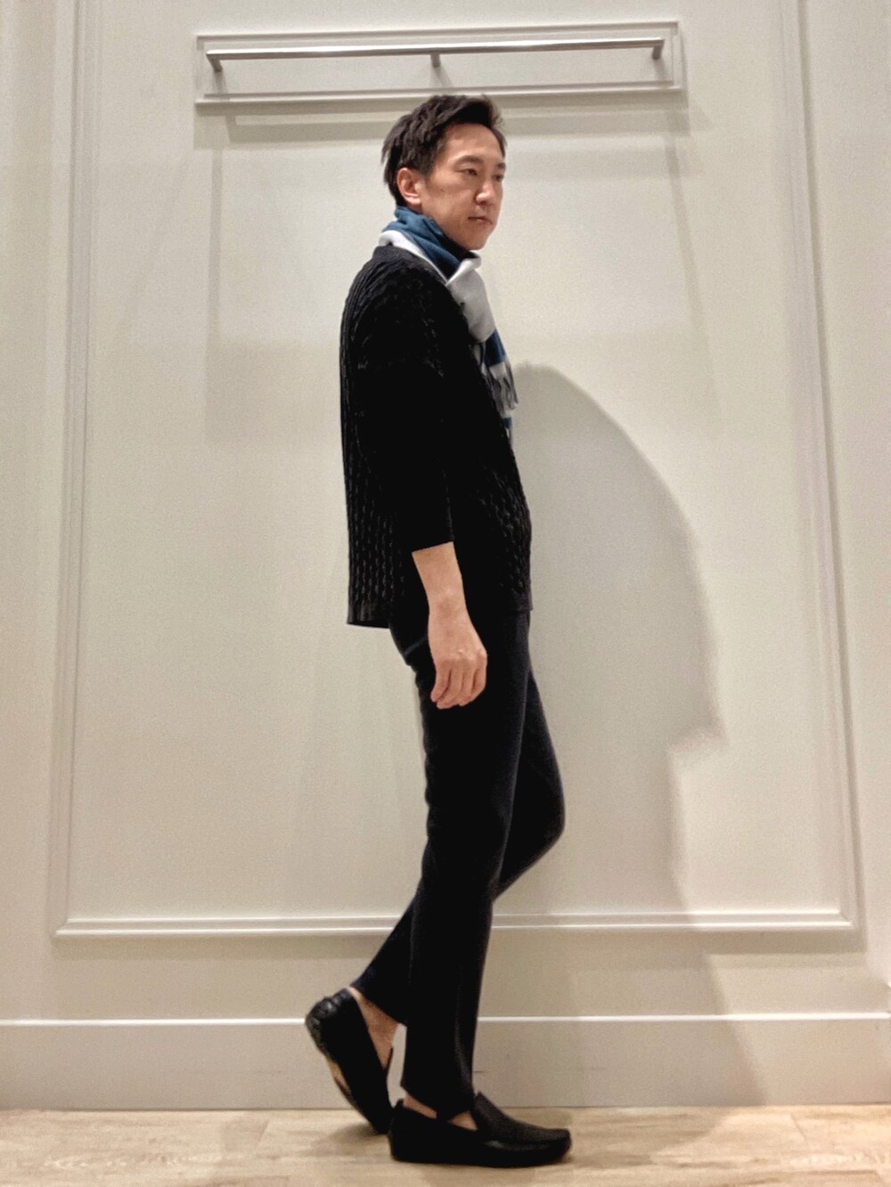 ブラック系のニット/セーター、ブルー系のその他パンツ、ブルー系のマフラーを着用したメンズの冬コーディネートの5枚目の写真