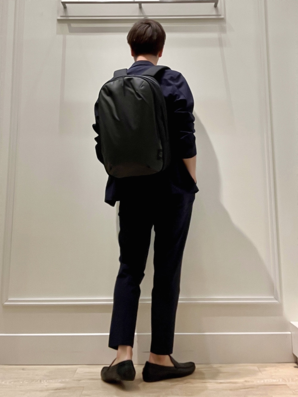 ブルー系のテーラードジャケット、ブラック系のバックパック/リュック、ブルー系のその他パンツを着用したメンズの冬コーディネートの4枚目の写真