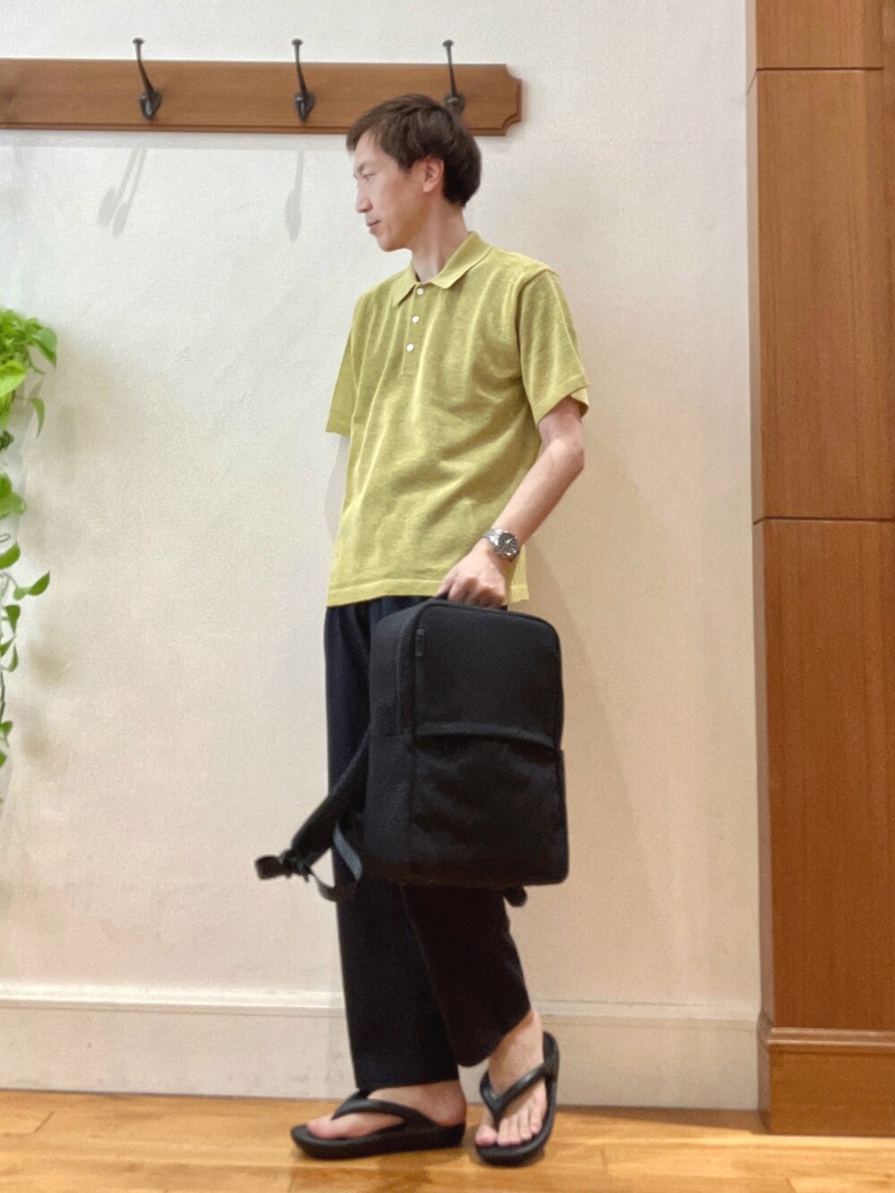イエロー系のニット/セーター、ブルー系のその他パンツ、ブラック系のバックパック/リュックを着用したメンズの春コーディネートの2枚目の写真