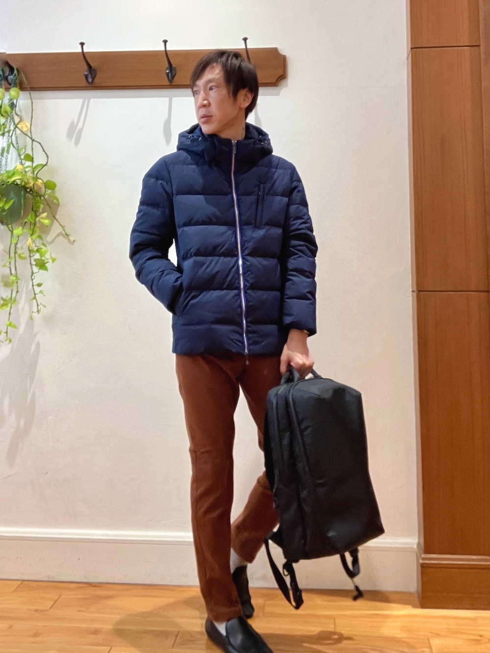 ブルー系のダウンジャケット/コート、イエロー系のチノパンツ、ブラック系のバックパック/リュックを着用したメンズの冬コーディネートの8枚目の写真