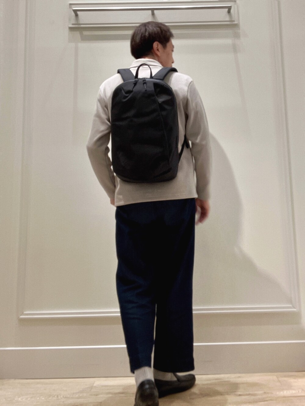 ベージュ系のカーディガン/ボレロ、ブラック系のバックパック/リュックを着用したメンズの冬コーディネートの4枚目の写真