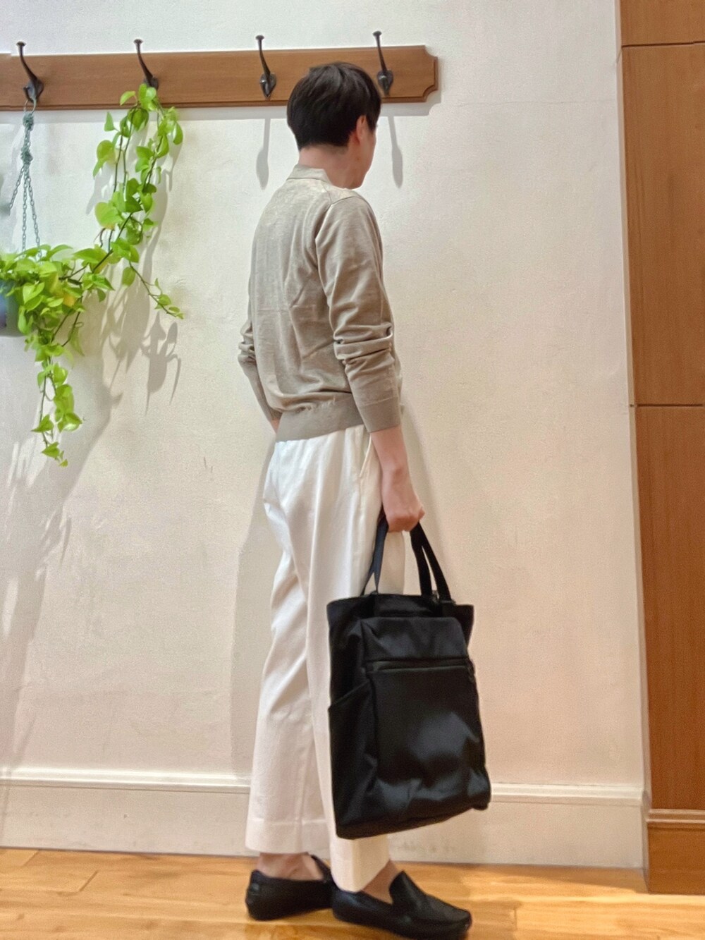 ホワイト系のデニムパンツ、ブラック系のトートバッグ、ベージュ系のニット/セーターを着用したメンズの冬コーディネートの7枚目の写真