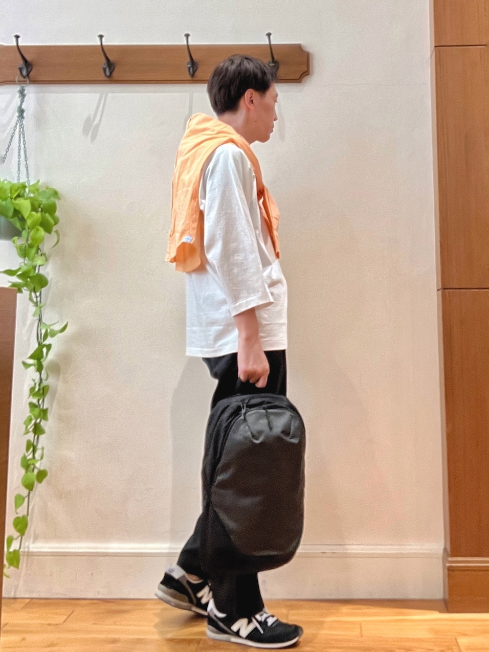 オレンジ系のシャツ/ブラウス、ブラック系のその他パンツ、グレー系のバックパック/リュックを着用したメンズの春コーディネートの6枚目の写真