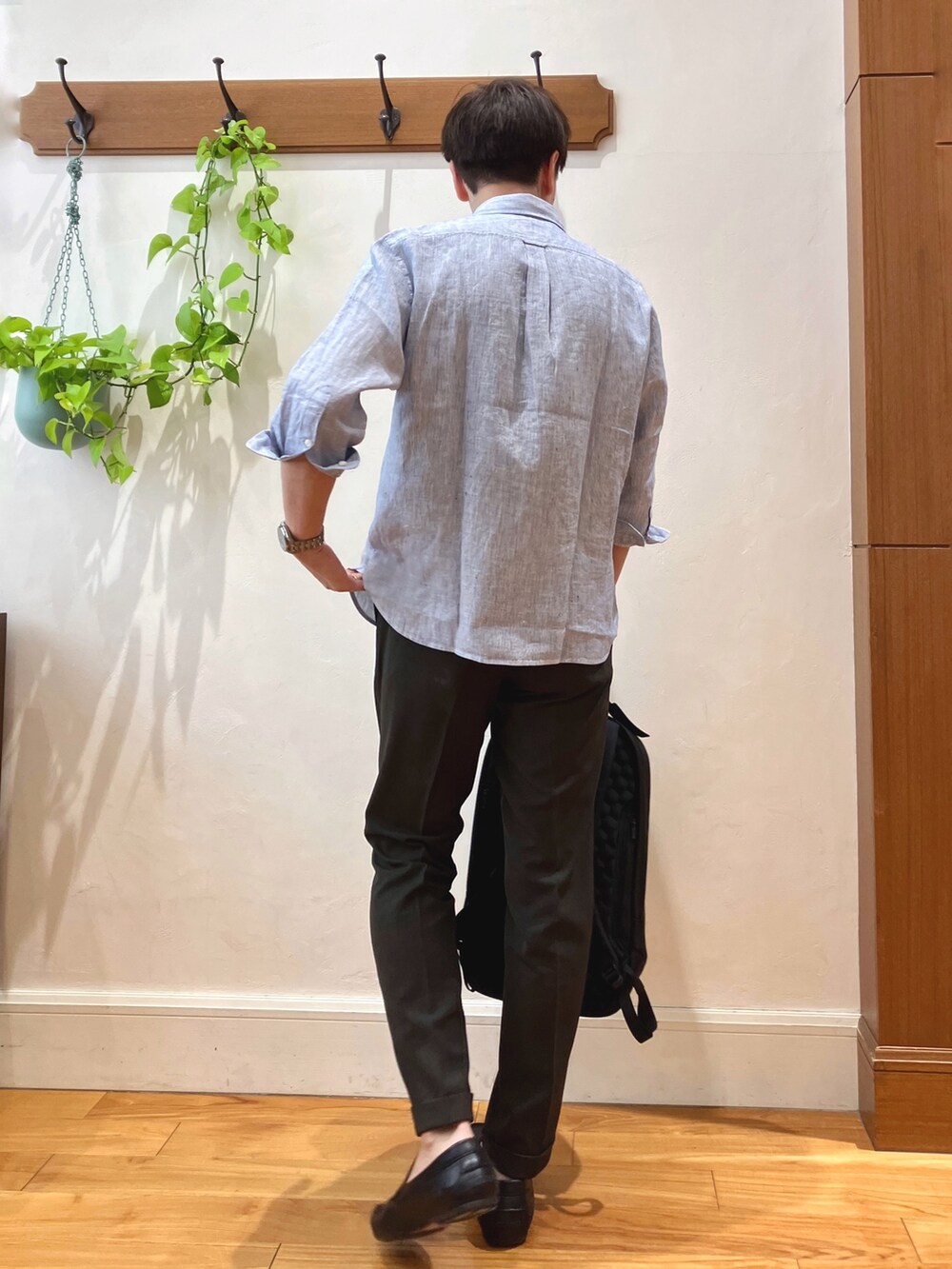 ブルー系のシャツ/ブラウス、ブラウン系のスラックス、ブラック系のバックパック/リュックを着用したメンズの春コーディネートの5枚目の写真