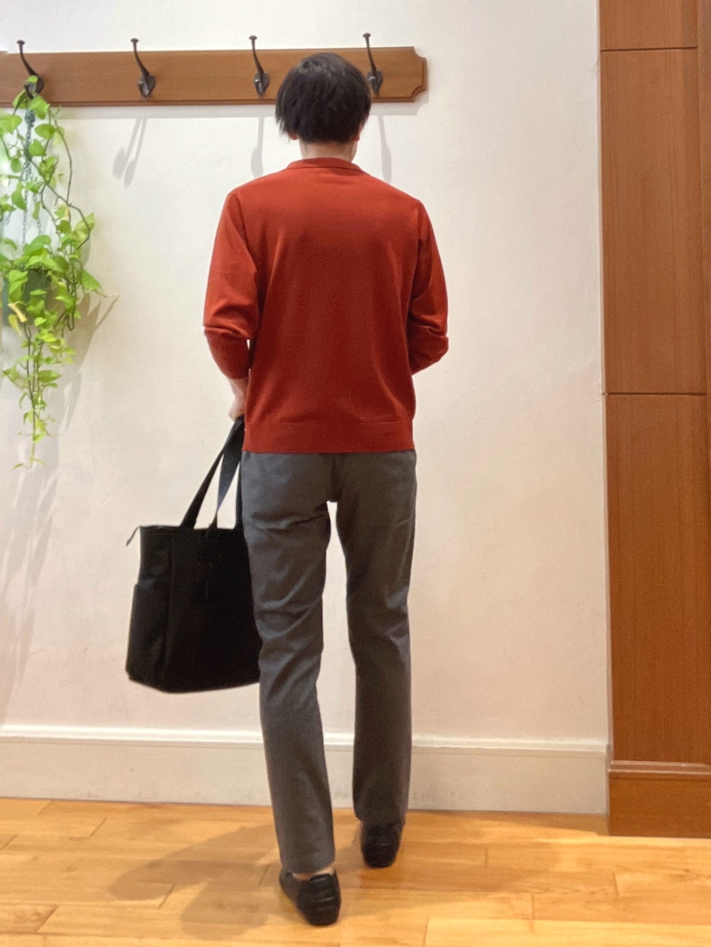 グレー系のその他パンツ、レッド系のニット/セーター、ブラック系のトートバッグを着用したメンズの秋コーディネートの4枚目の写真
