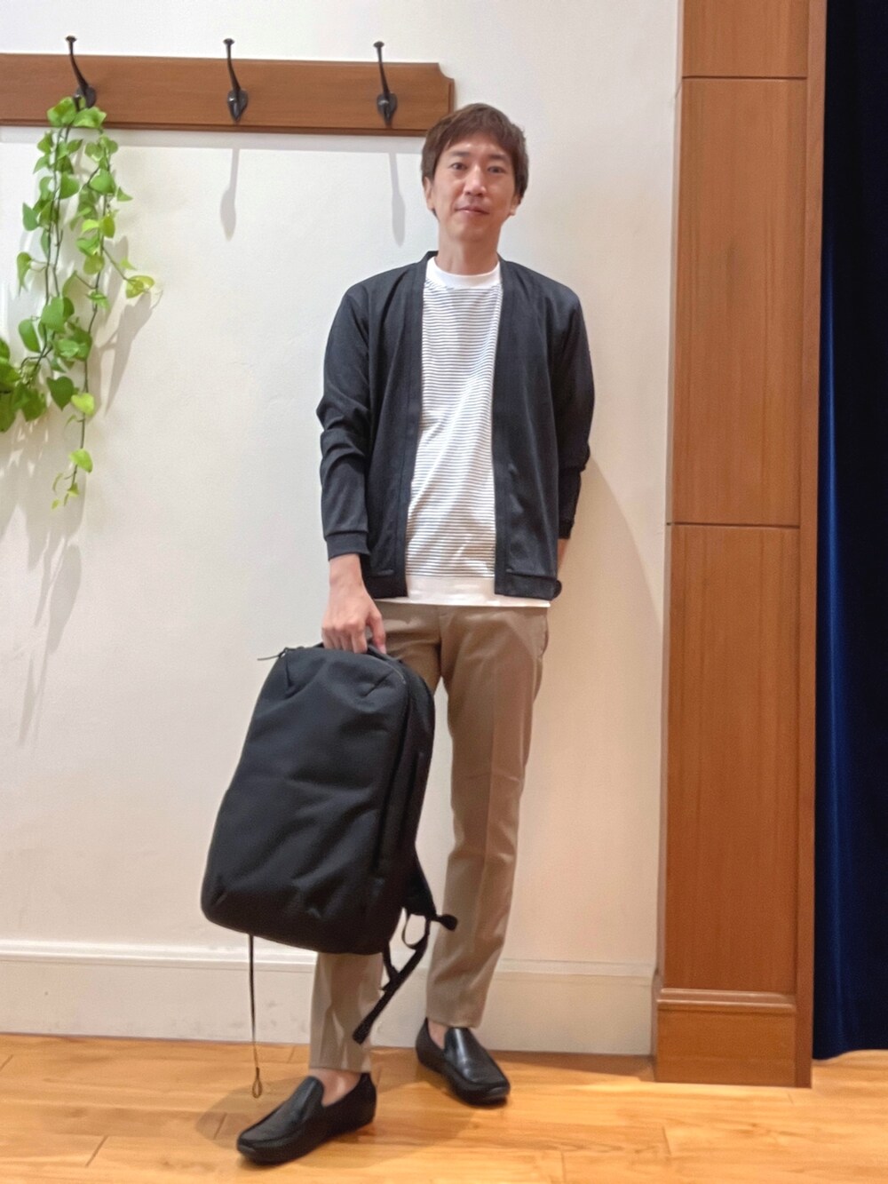 ブルー系のカーディガン/ボレロ、ホワイト系のTシャツ/カットソー、ブラック系のバックパック/リュックを着用したメンズの秋コーディネートの2枚目の写真