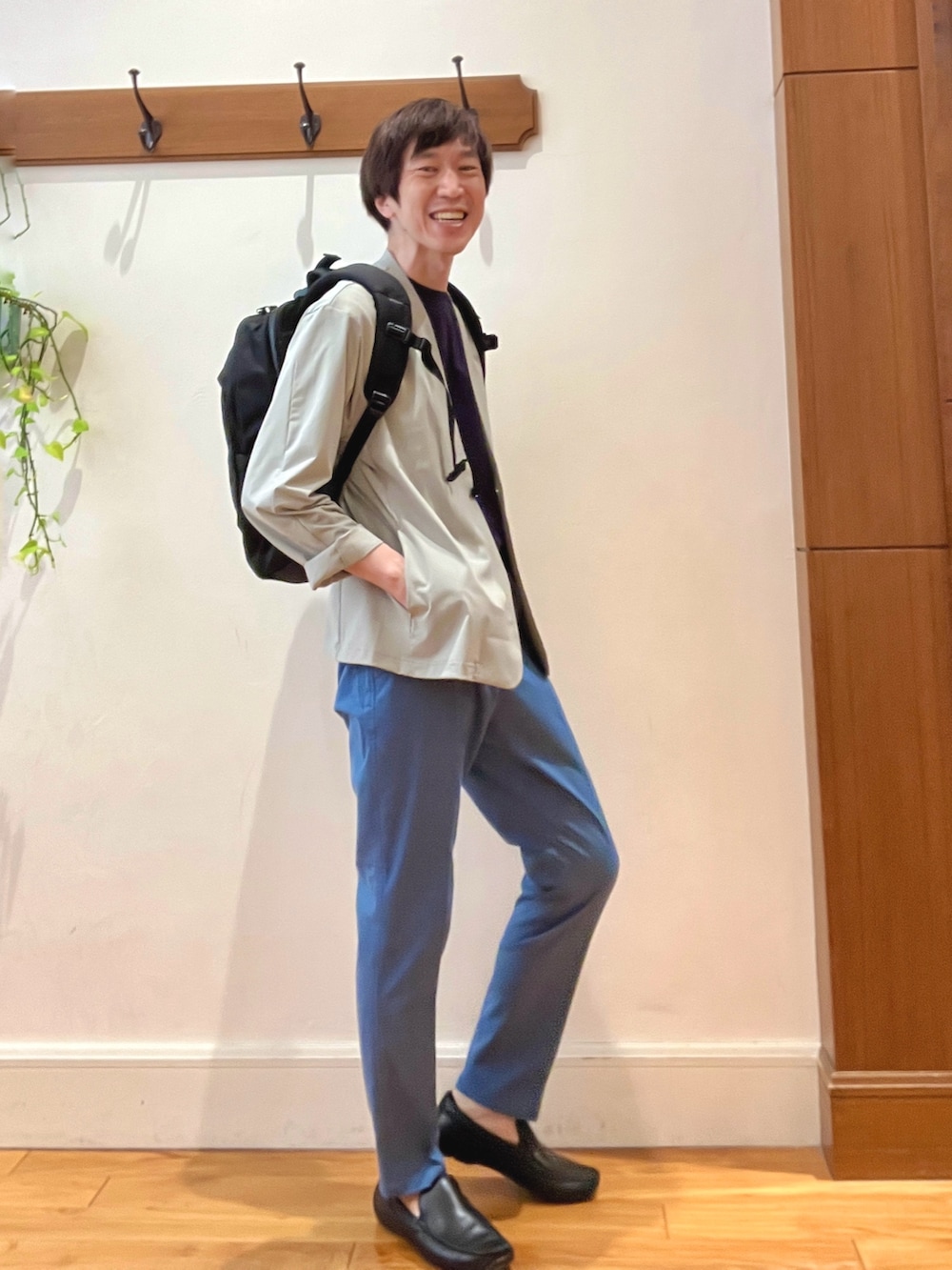ブラック系のバックパック/リュック、ブルー系のチノパンツ、ブルー系のTシャツ/カットソーを着用したメンズの春コーディネートの7枚目の写真