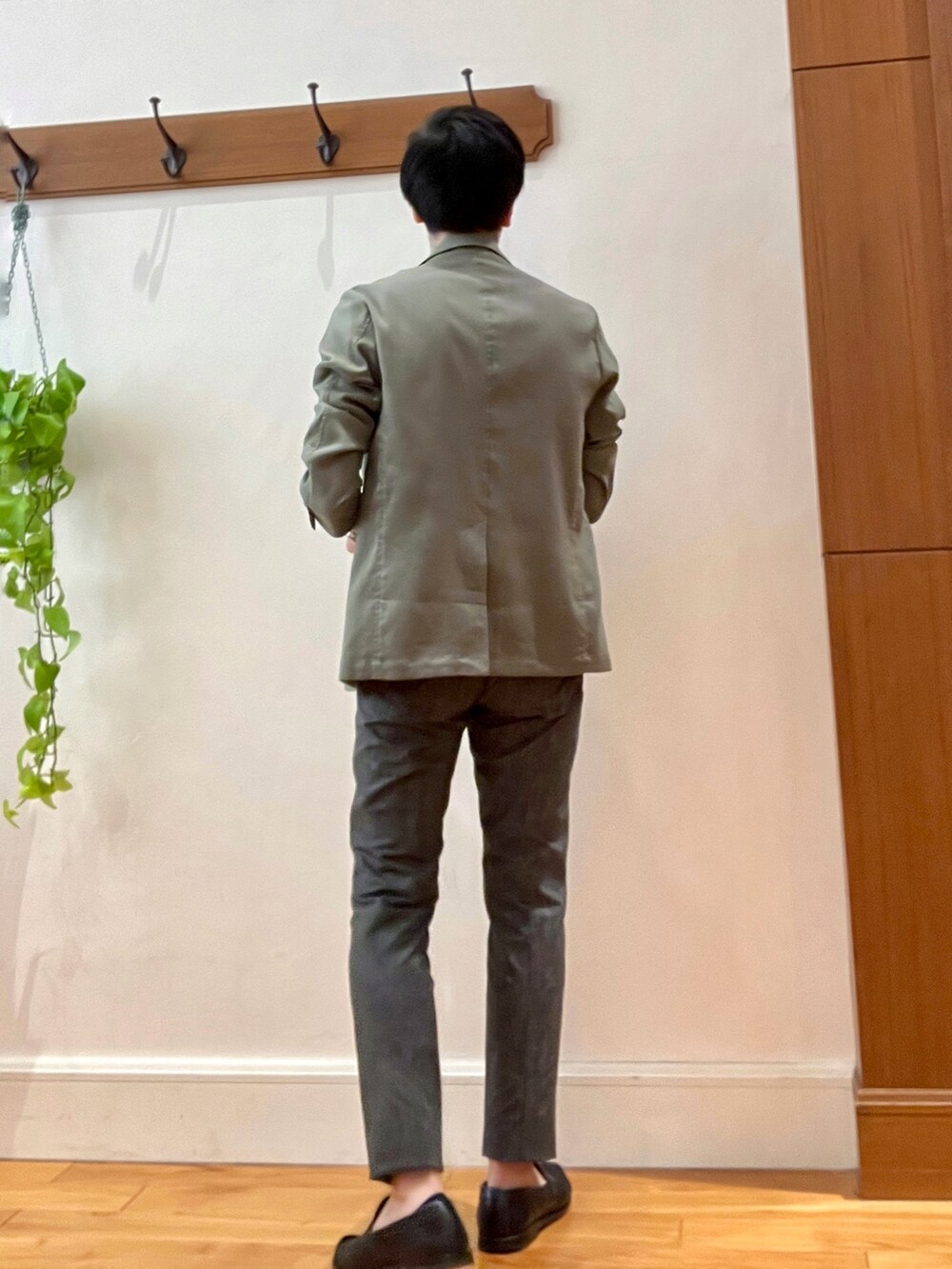 グリーン系のテーラードジャケット、ブラック系のポロシャツ、グレー系のその他パンツを着用したメンズの春コーディネートの5枚目の写真