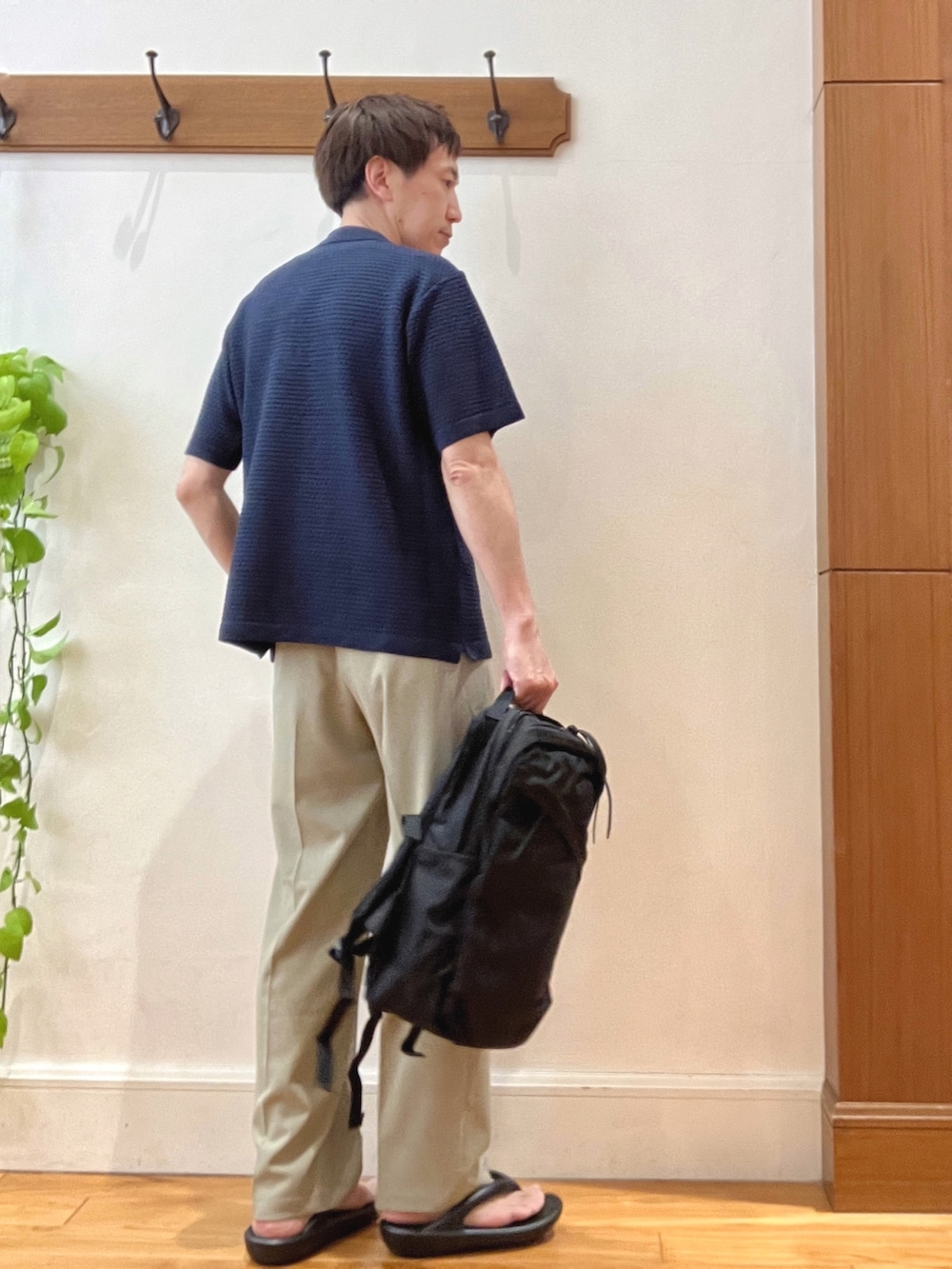 ブルー系のポロシャツ、ベージュ系のその他パンツ、ブラック系のバックパック/リュックを着用したメンズの春コーディネートの6枚目の写真