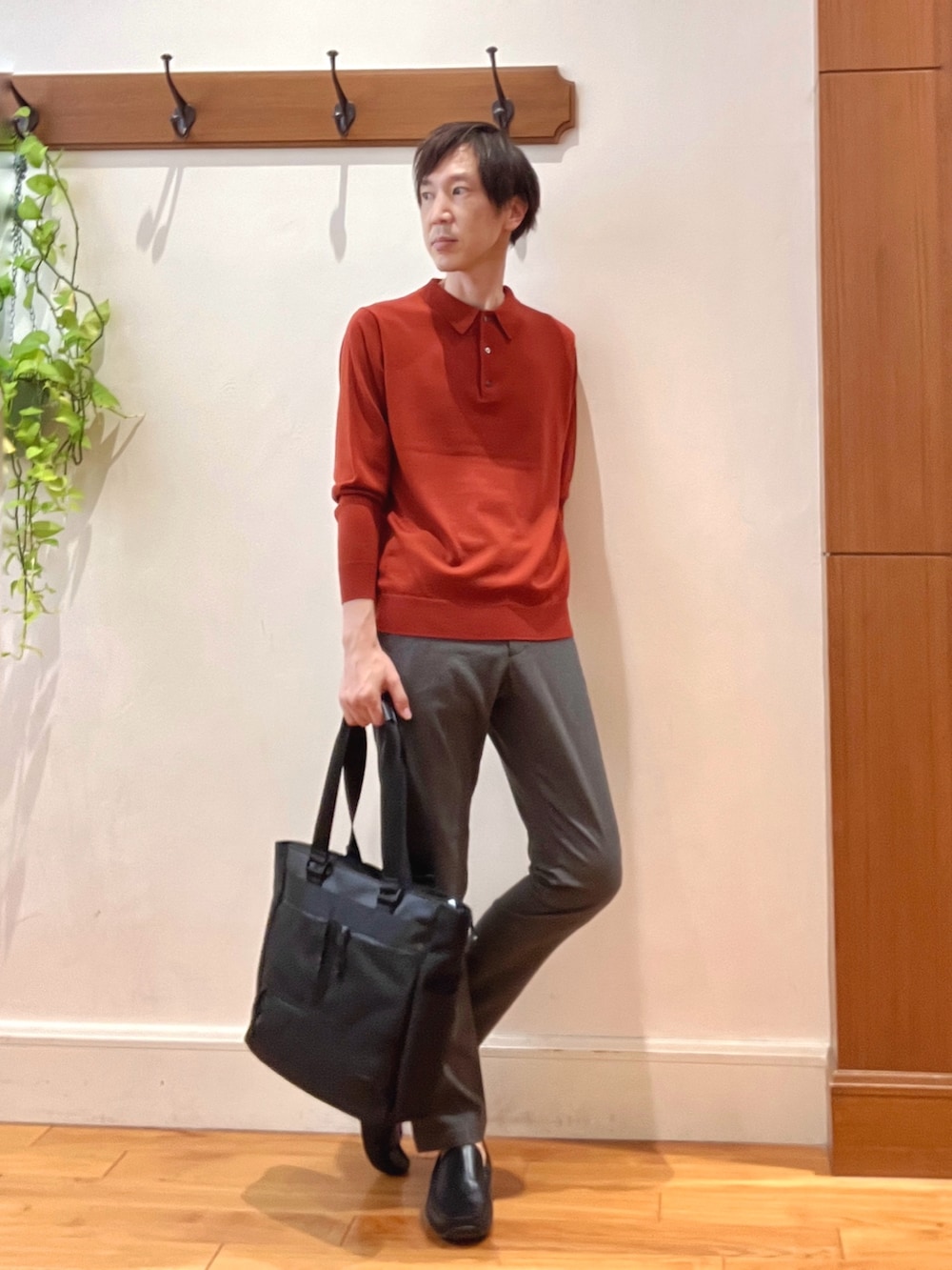 グレー系のその他パンツ、レッド系のニット/セーター、ブラック系のトートバッグを着用したメンズの秋コーディネートの6枚目の写真