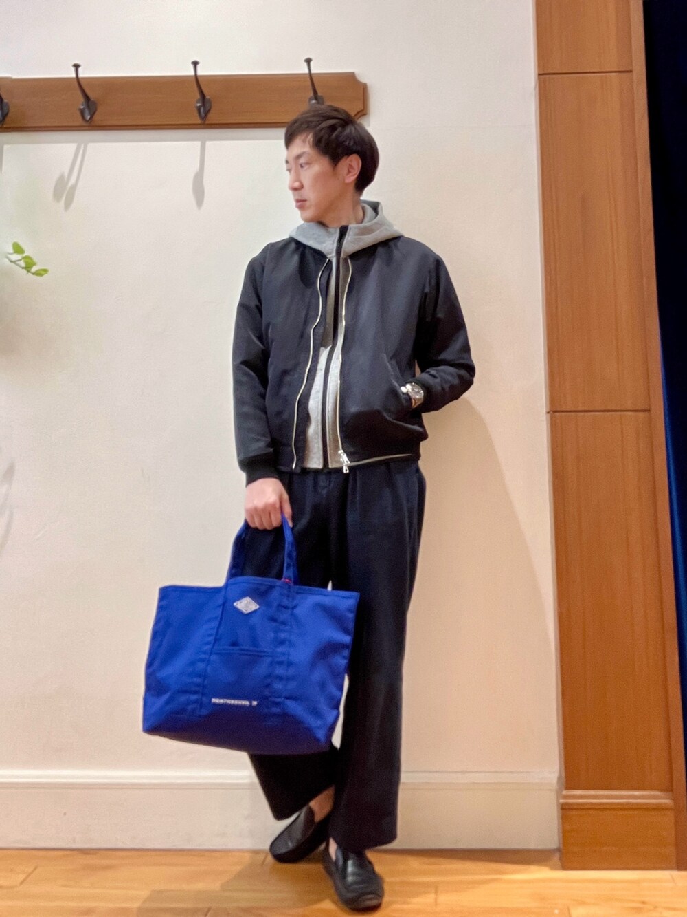 ブラック系のブルゾン、グレー系のパーカー、ブルー系のデニムパンツを着用したメンズの春コーディネートの7枚目の写真