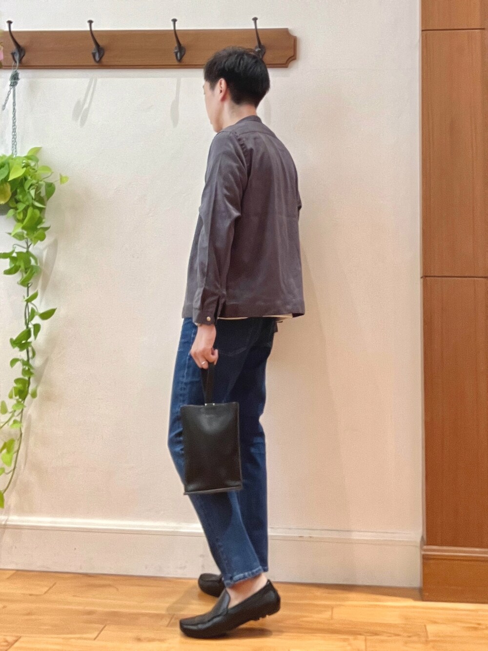 ブルー系のデニムパンツ、ブラック系のハンドバッグ、オレンジ系のTシャツ/カットソーを着用したメンズの秋コーディネートの4枚目の写真