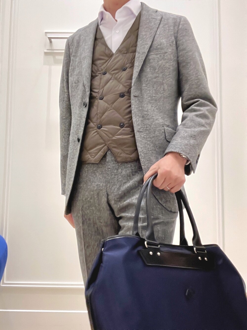 グレー系のテーラードジャケット、グレー系のスラックス、ブラック系のトートバッグを着用したメンズの秋コーディネートの8枚目の写真