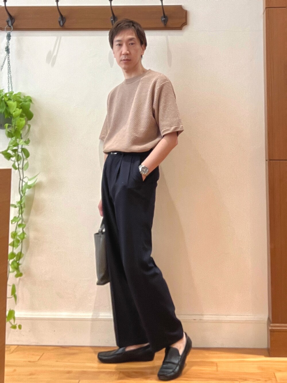 ベージュ系のニット/セーター、ブラック系のその他パンツ、グレー系のショルダーバッグを着用したメンズの春コーディネートの4枚目の写真